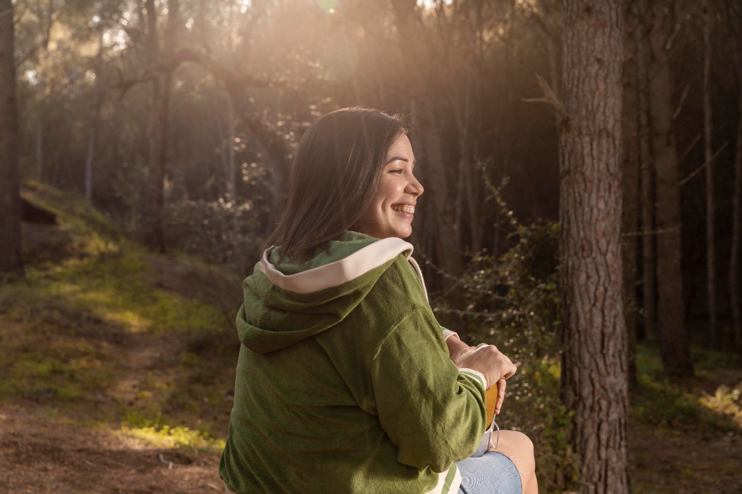 A woman smiling in nature, finding peace with Warrenville Therapist.