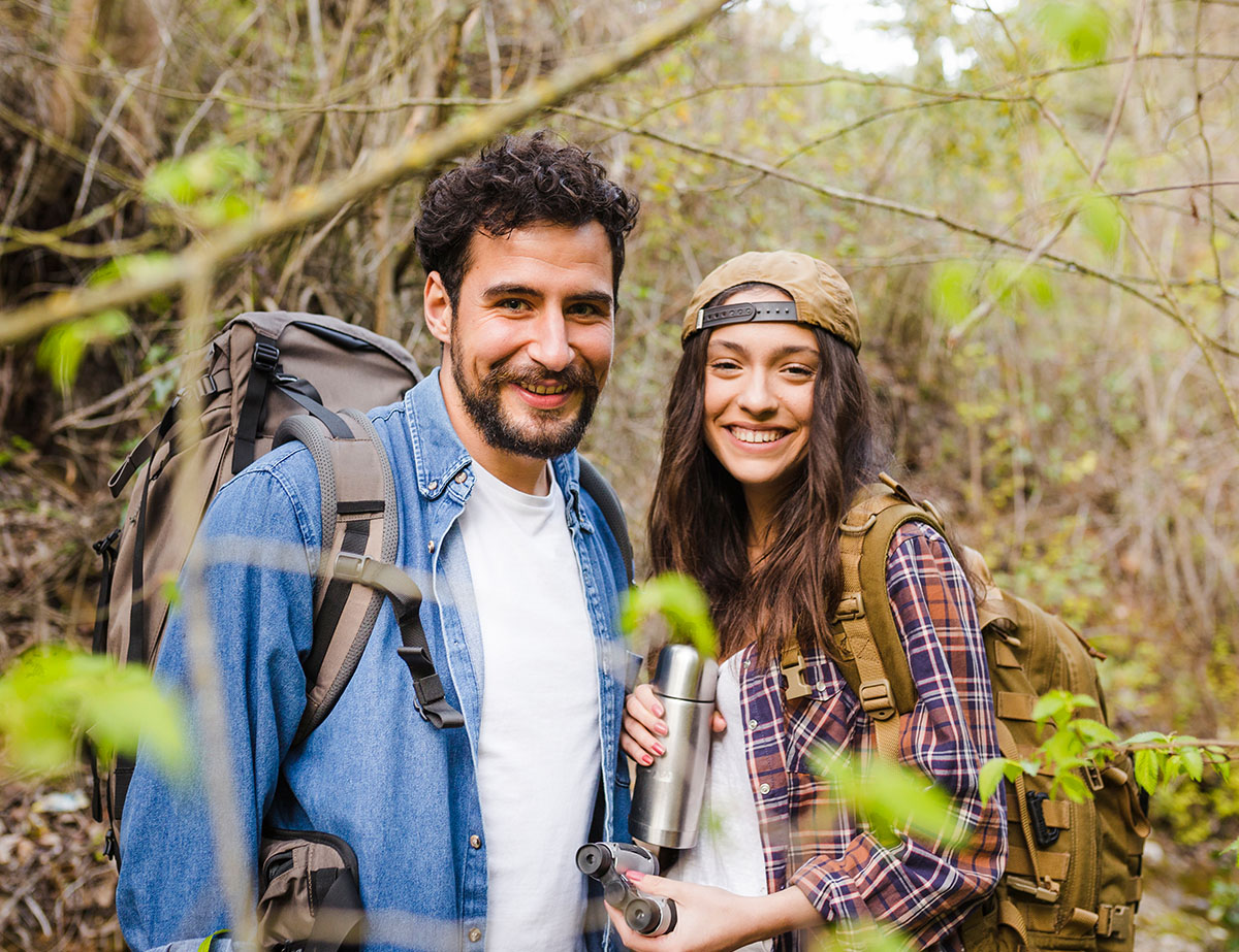 Positive female and male tourist wanders near mountain river in woods after receiving TMS therapy in Naperville IL